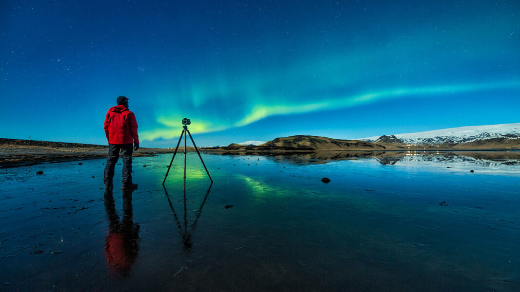 climate research - photo of a man taking a photo of the Northern Lights