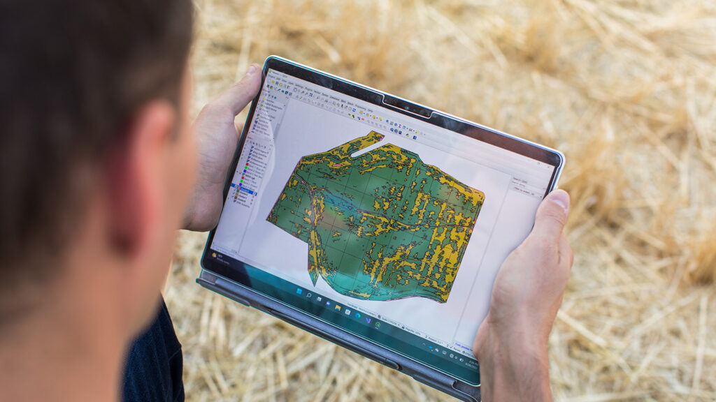 Andrew Nelson studies a FarmVibes.AI image on a tablet