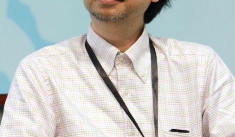 a man wearing glasses and smiling at the camera