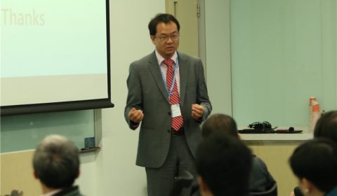 a group of people standing next to a man in a suit and tie