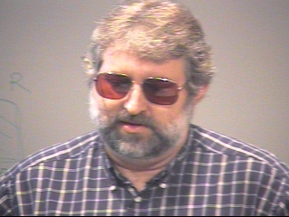 a man wearing glasses and looking at the camera