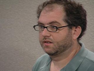 a man wearing glasses and looking at the camera