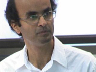 a man wearing glasses and looking at the camera