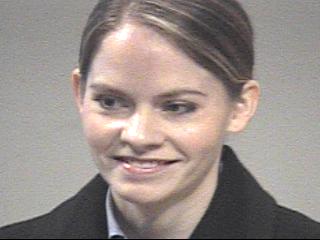 a man wearing a suit and tie smiling at the camera