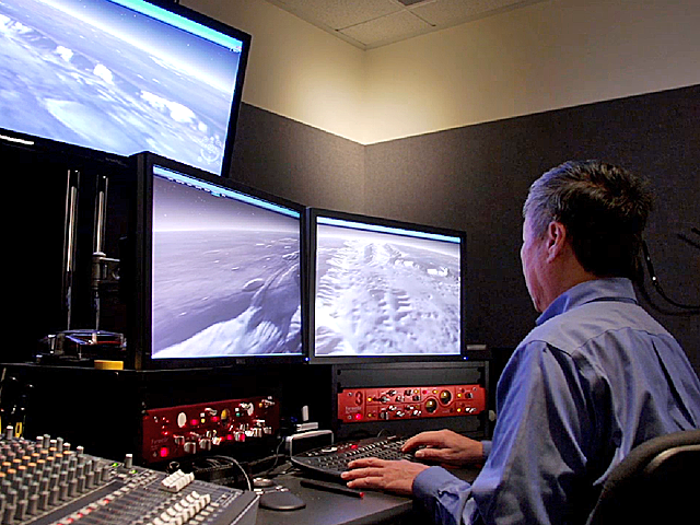 a man sitting at a desk with a computer monitor