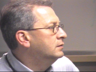 a man in glasses looking at the camera