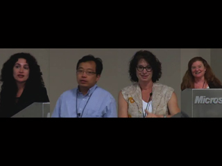 a group of people posing for a photo in front of a television screen