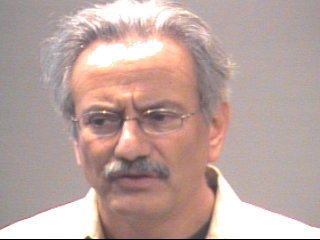 a man wearing glasses and smiling at the camera