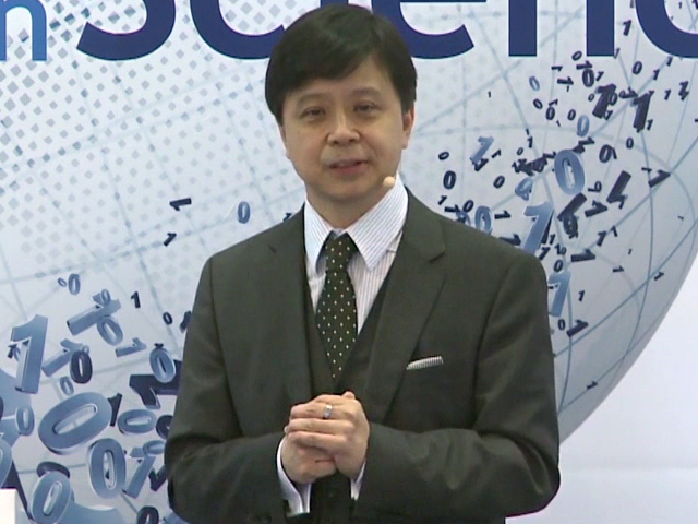 Hsiao-Wuen Hon holding a sign posing for the camera