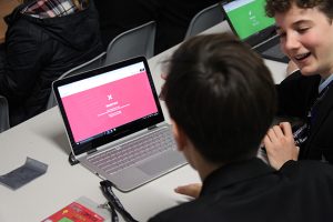 a group of people looking at a laptop