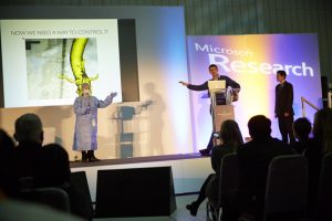 a group of people sitting at a desk in front of a computer screen