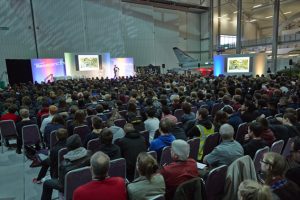 a group of people sitting in front of a large crowd of people
