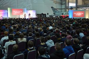 a group of people sitting in front of a large crowd of people