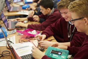 a group of people sitting at a table using a laptop computer