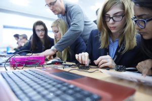 a group of people sitting at a table using a laptop