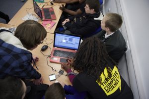 a group of people looking at a laptop