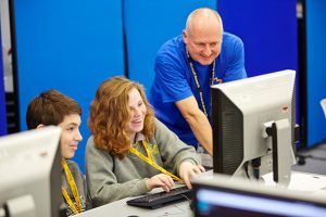 a group of people looking at a laptop