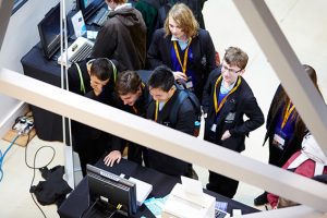 a group of people standing in front of a computer