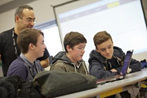 a group of people looking at a computer
