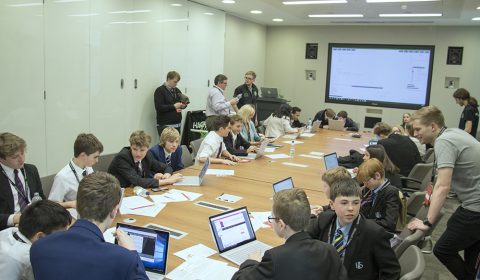 a group of people sitting at a table with a laptop computer