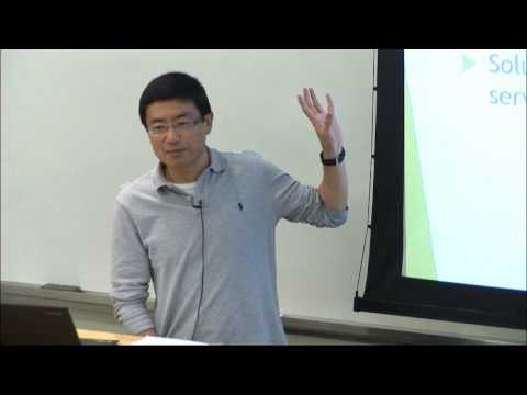 Cheng Huang standing in front of a screen