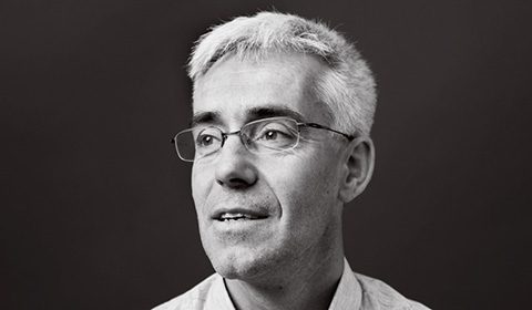 a man wearing glasses and looking at the camera