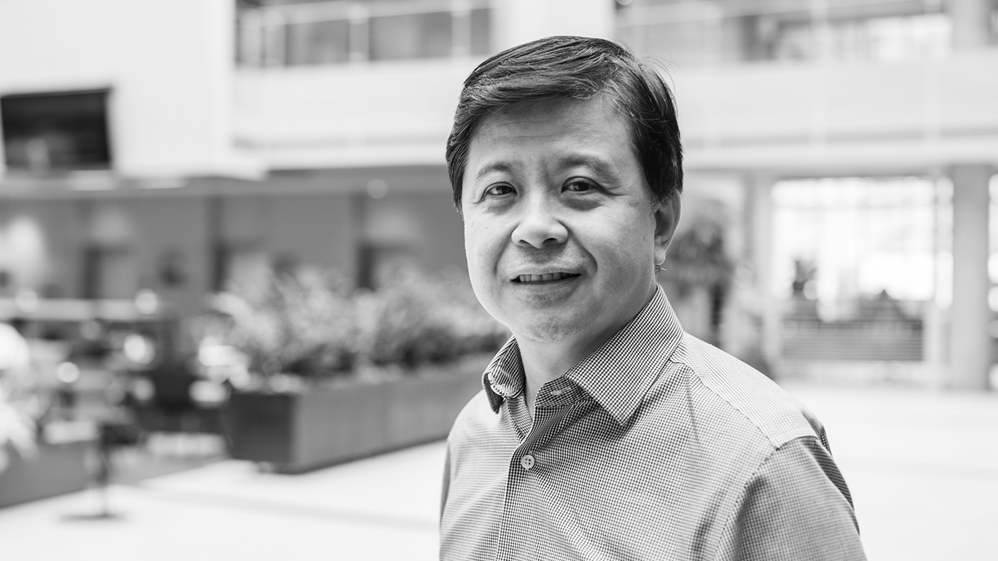 Hsiao-Wuen Hon wearing a suit and tie smiling at the camera