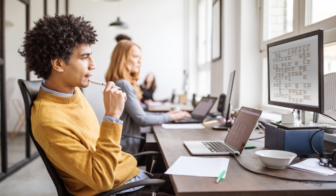 a person sitting at a table using a laptop