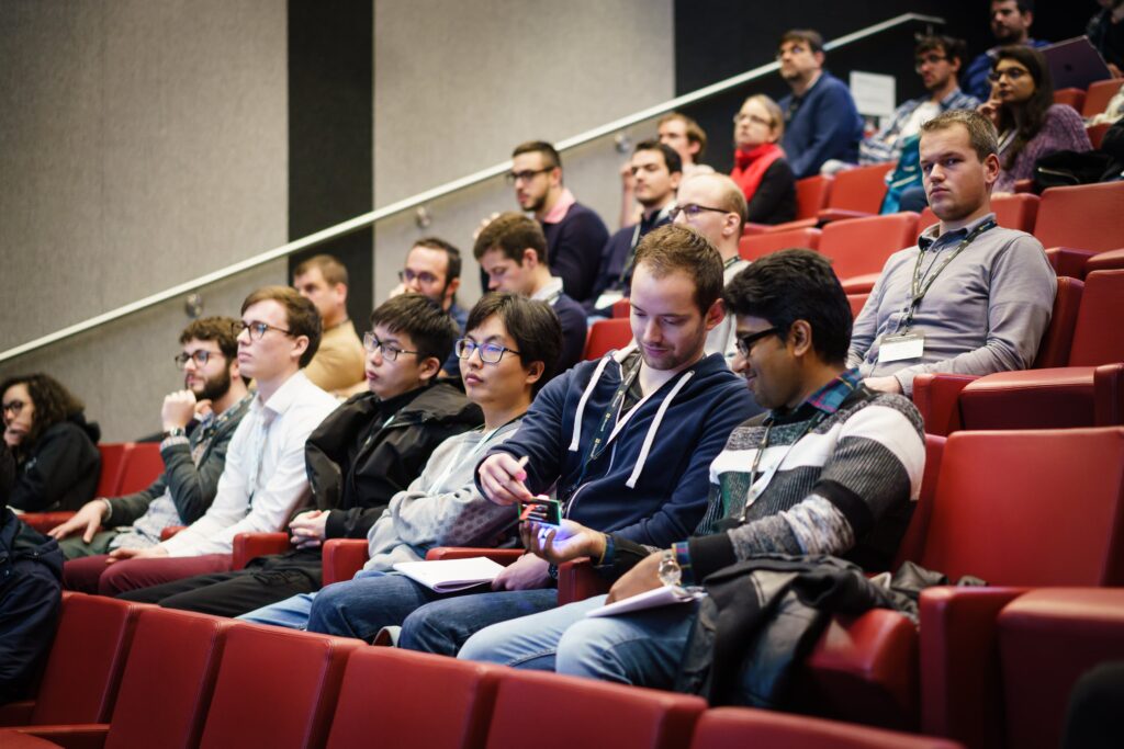 a group of people sitting in chairs in front of a crowd