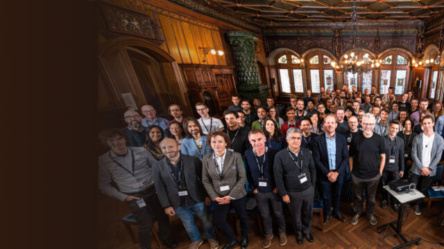 a group of people standing in front of a crowd posing for the camera