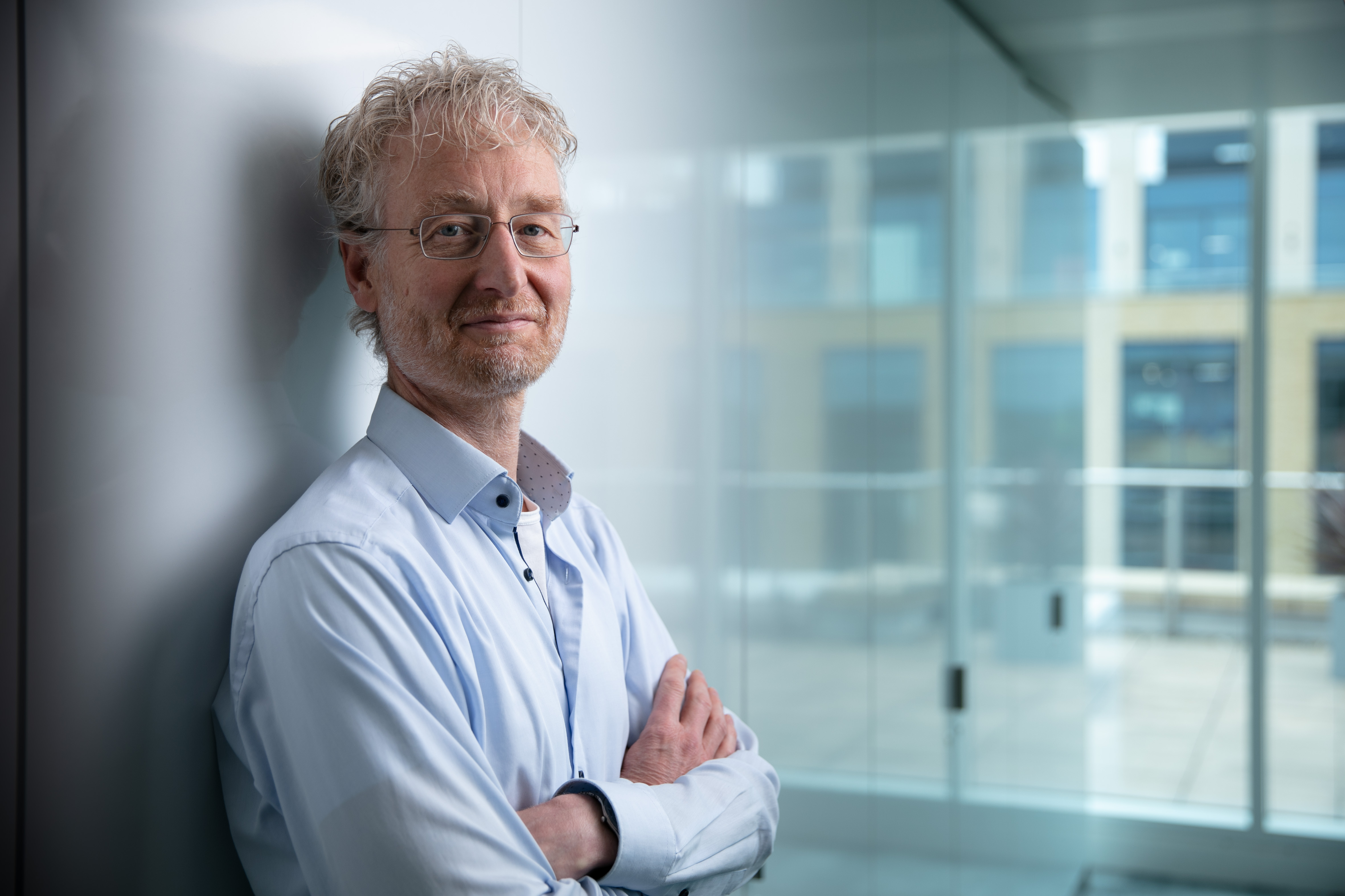 a man wearing glasses and smiling at the camera