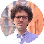 a man wearing glasses and smiling at the camera