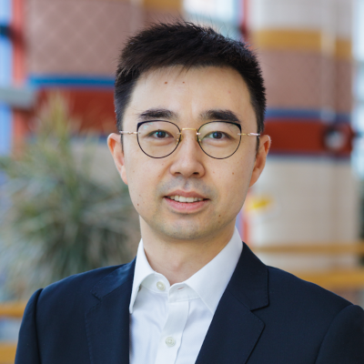 a man wearing a suit and tie smiling at the camera