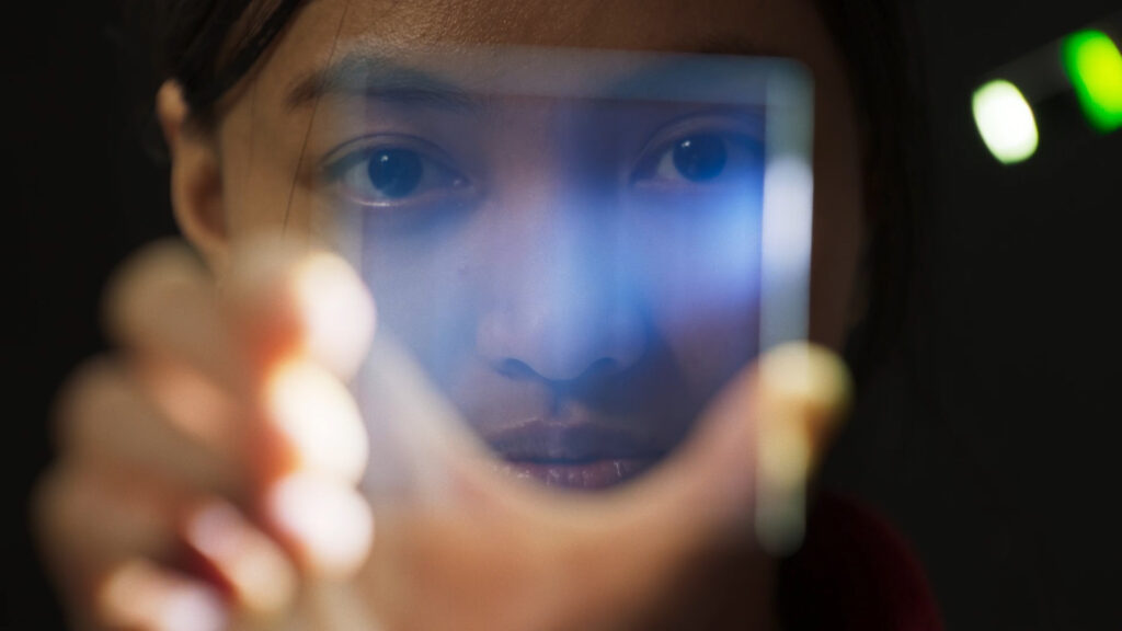 woman holding glass in front of her face