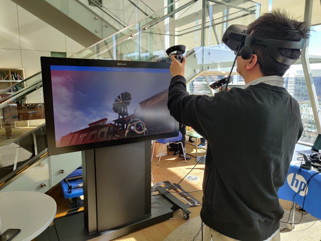 在研究院的实习生社团活动中，李琨体验 VR 游戏设备