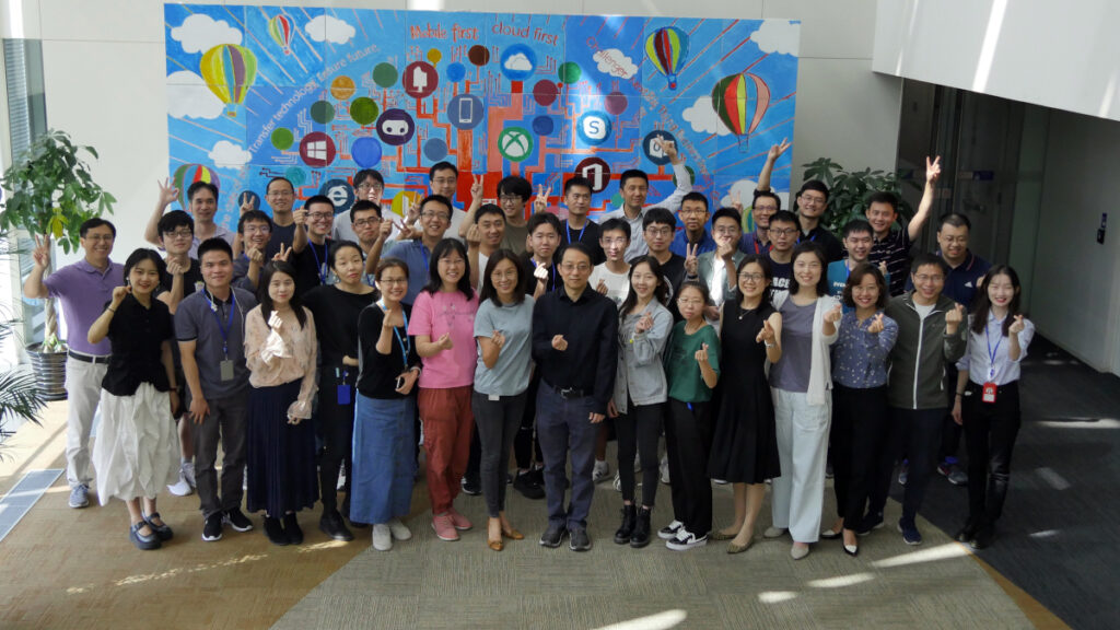 a group of people standing in front of a crowd posing for the camera