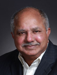 Raj Reddy wearing a suit and tie smiling at the camera