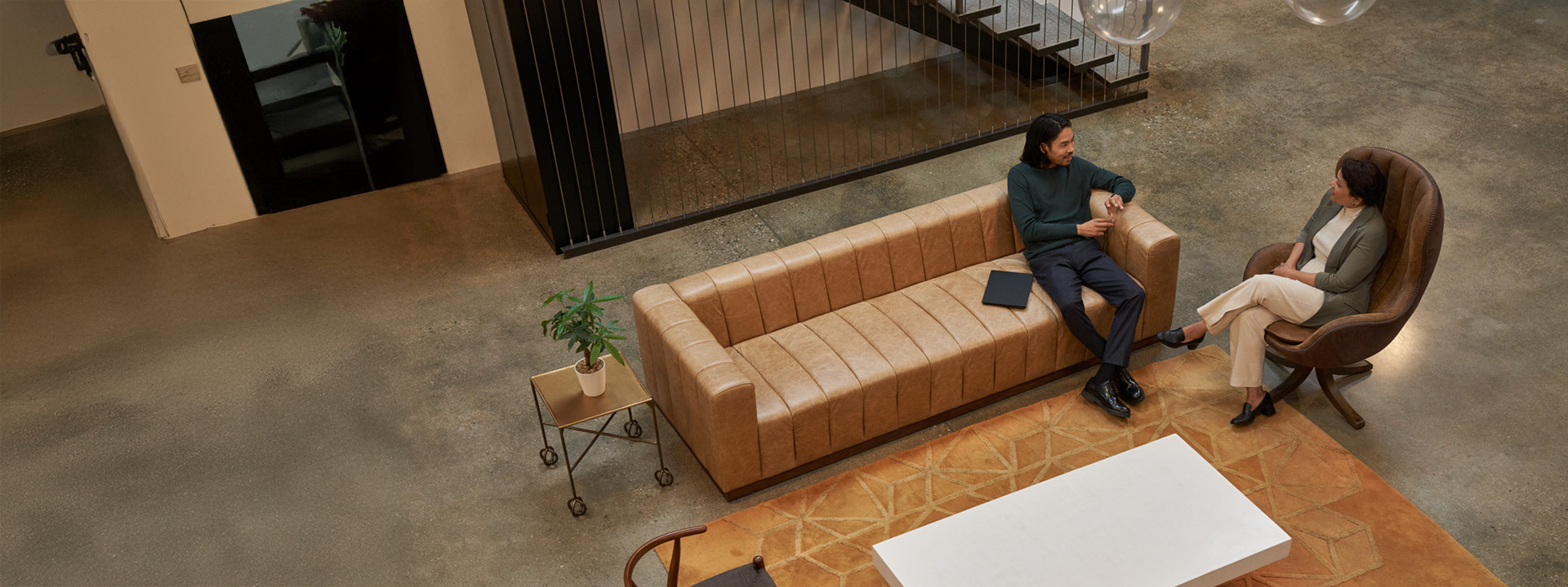 overhead view of two people talking while relaxing in an office lounge area