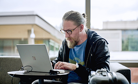Image of a man working at a laptop.