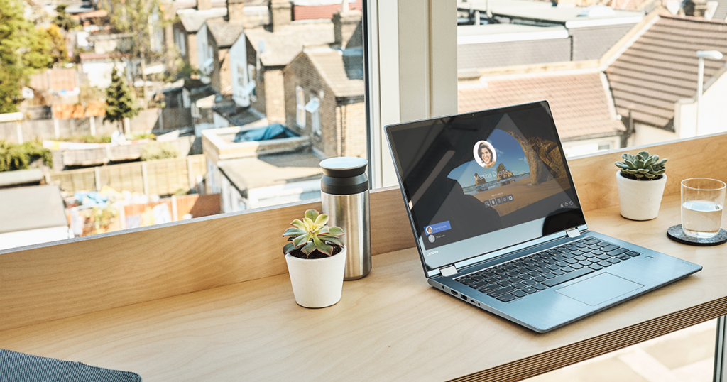 Image of a laptop open on a countertop, a cityscape in the distance.