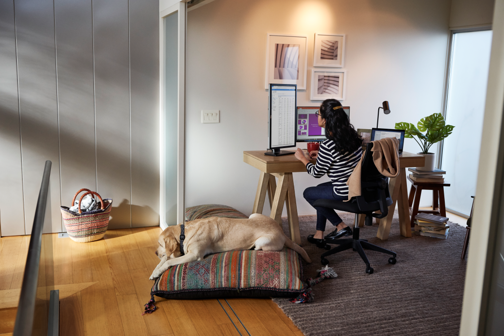 Female working remotely from her home office on a Dell Latitude device.