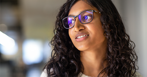 An image of a female developer smiling off camera.