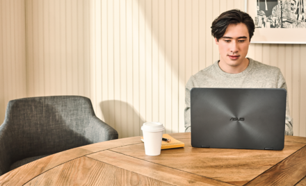 Young man interacting with an Asus Zenbook laptop.