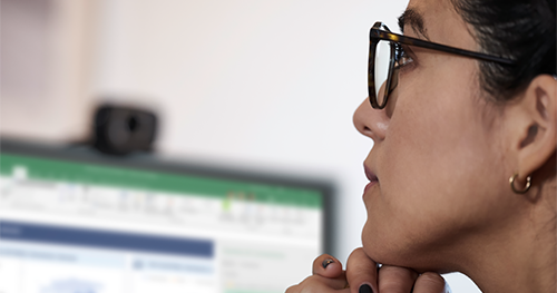 Tight shot of female thinking at her desk in front of an HP Elitebook device.