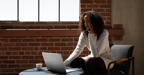 An image of adult female working on Surface Book 3.