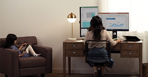An image of a mother and her daughter are working and learning remotely in their living room.