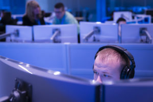Man working while wearing headphones in the Microsoft Cyber Defense Operations Center