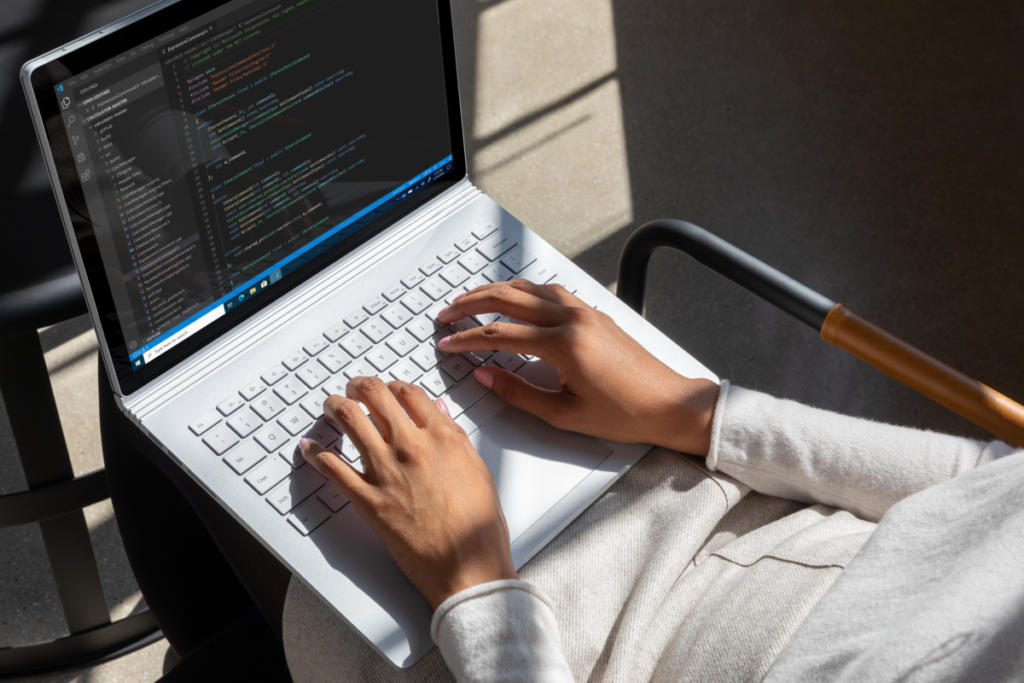 Commercial contextual lifestyle image of adult female working in Azure on Surface Book 3 inside.