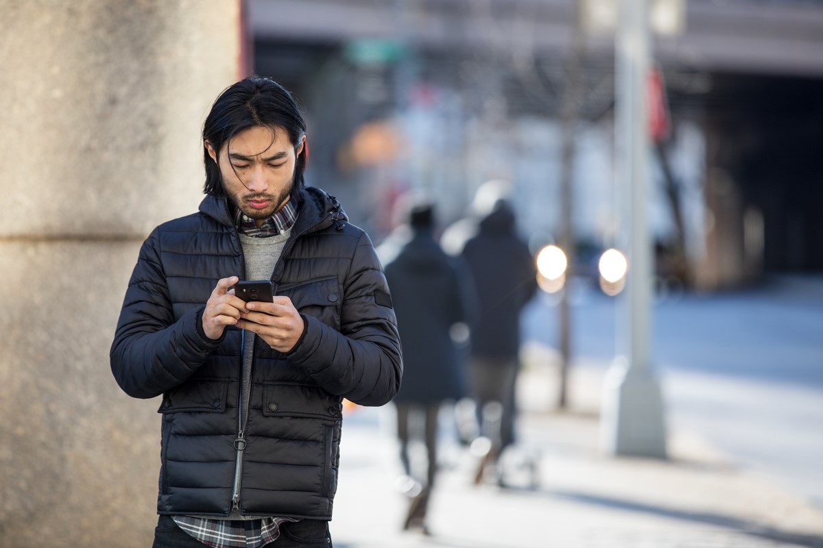 Small business male achieving outside the office (mobile) using a phone.