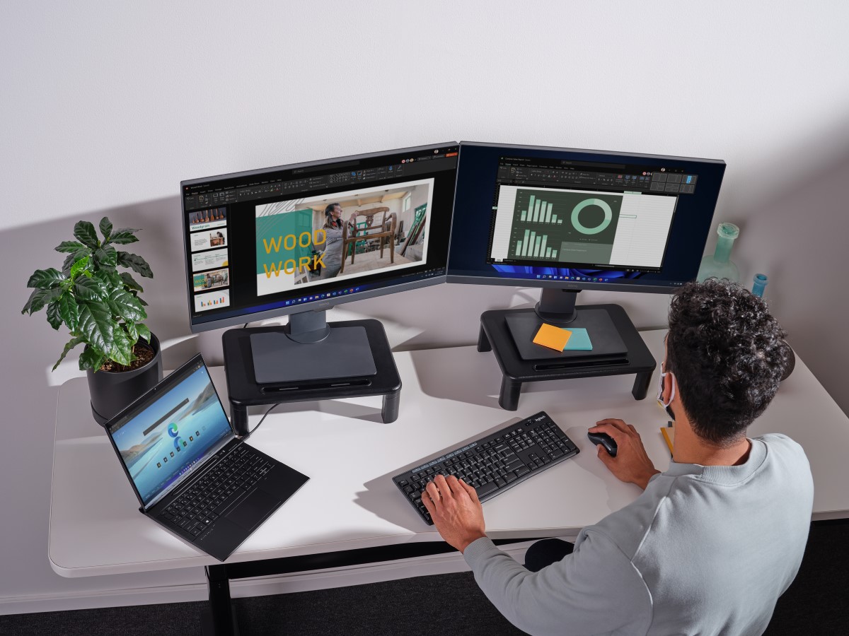 Adult male sitting in home office working on multiple screens.